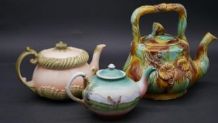 A collection of three antique teapots. Two majolica tea pots, one with sea shells and one with