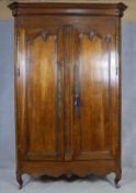 A 19th century French chestnut armoire with panel doors enclosing shelved interior above shell