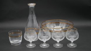 A gilded foliate design glass decanter with matching bowl, tumbler and four gilded and etched cognac