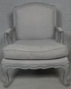 A painted Louis XV style armchair in double piped calico upholstery on carved scrolling cabriole