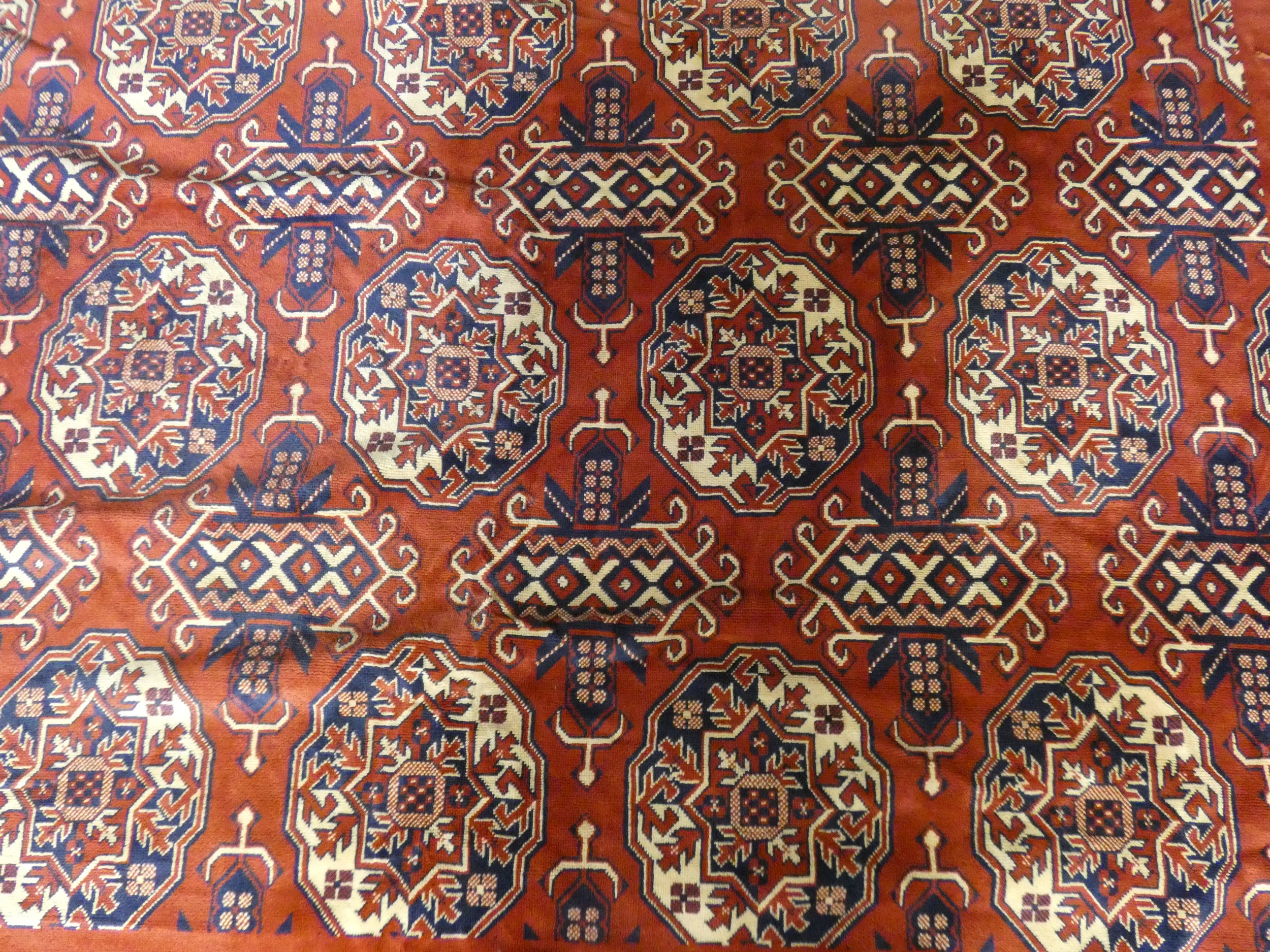 A Bokhara style carpet with repeating gull motifs on a madder field in a plain border along with a - Image 10 of 11
