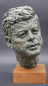 A bronze effect plaster bust of John F. Kennedy on plinth base. H.29cm
