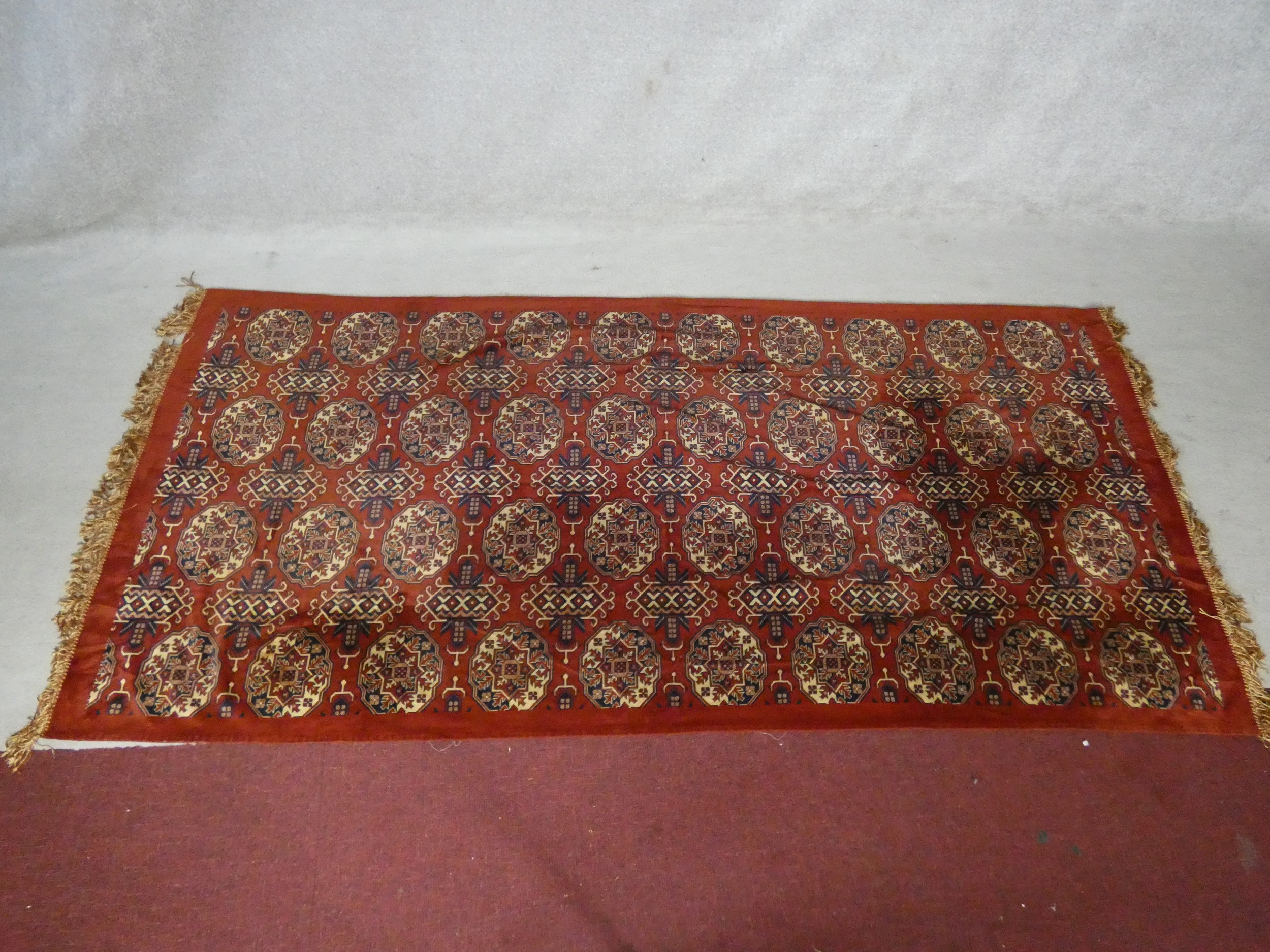 A Bokhara style carpet with repeating gull motifs on a madder field in a plain border along with a - Image 9 of 11