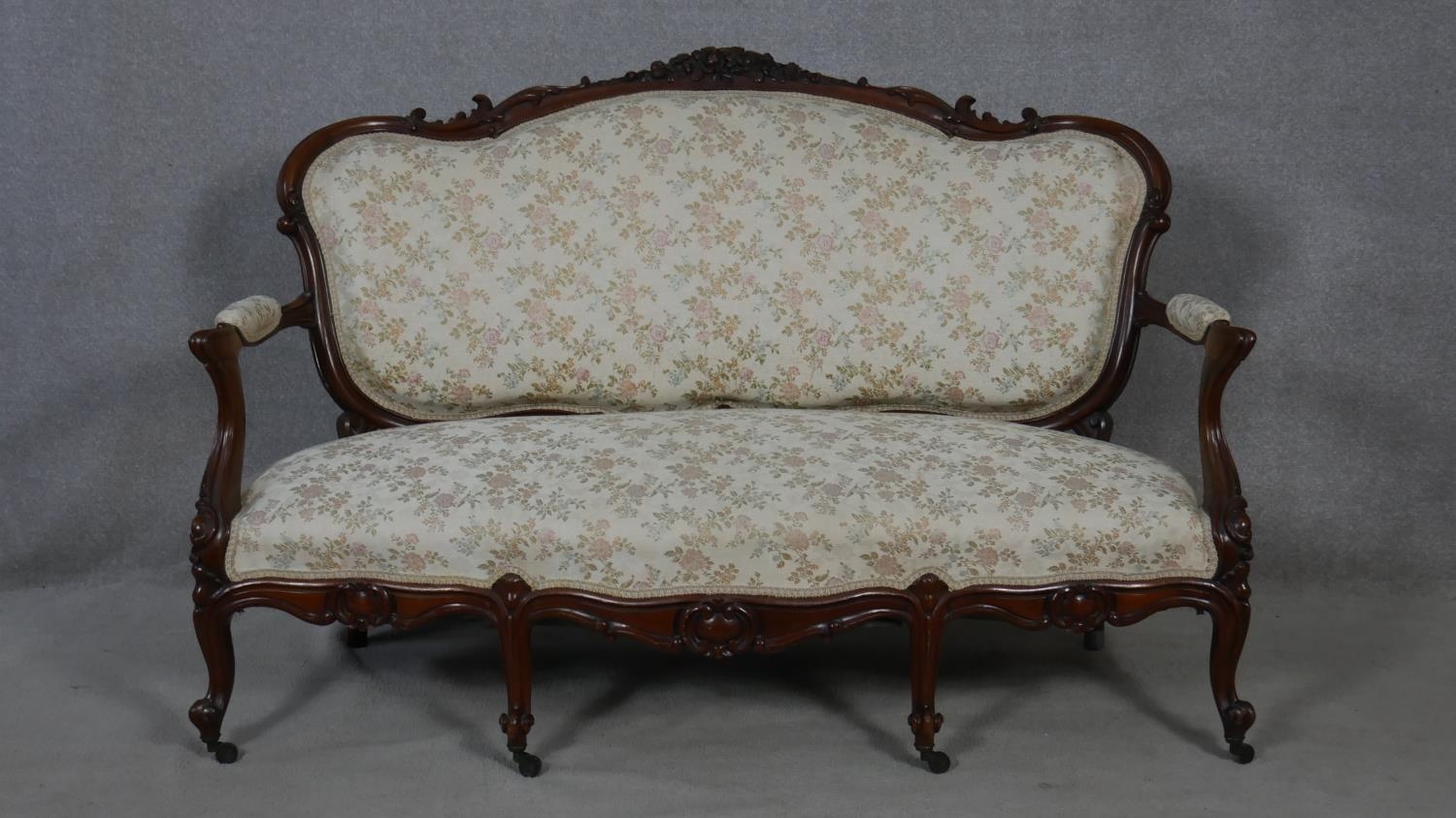 A 19th century carved mahogany canape in floral upholstery with four cabriole front supports. H.99