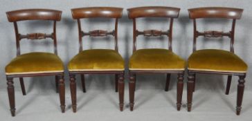 A set of four William IV mahogany bar back dining chairs with acanthus carved splats above stuff