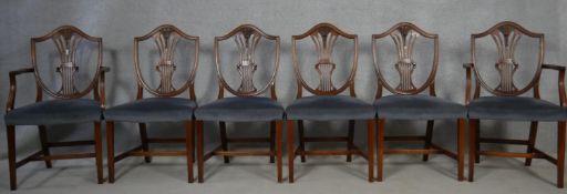 A set of six mahogany Hepplewhite style dining chairs with pierced wheatsheaf backs above stuff over