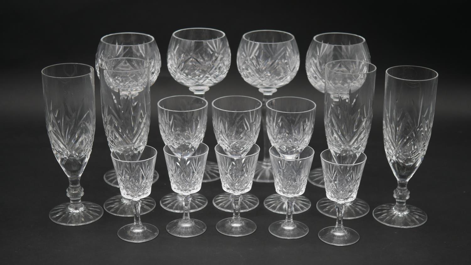 A collection of sixteen cut crystal glasses. Including a set of four foliate design wine glasses,