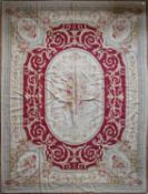 A handmade needlepoint rug with double floral central medallions contained by flower and vine