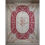 A handmade needlepoint rug with double floral central medallions contained by flower and vine