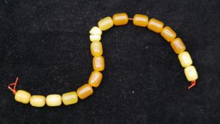 A string of seventeen antique amber prayer beads. (one cracked) L.24cm