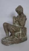 A bronze effect fibre glass figure of a seated girl sewing, indistinctly signed. H.33cm