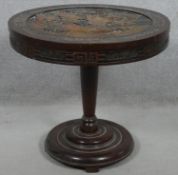 A Chinese carved teak tilt top table on pedestal platform base. H.56 D.60.5cm