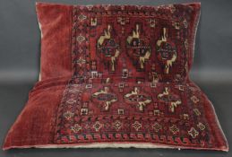 A large Bokhara style cushion with gul motifs on a burgundy ground. L.100 W.78cm