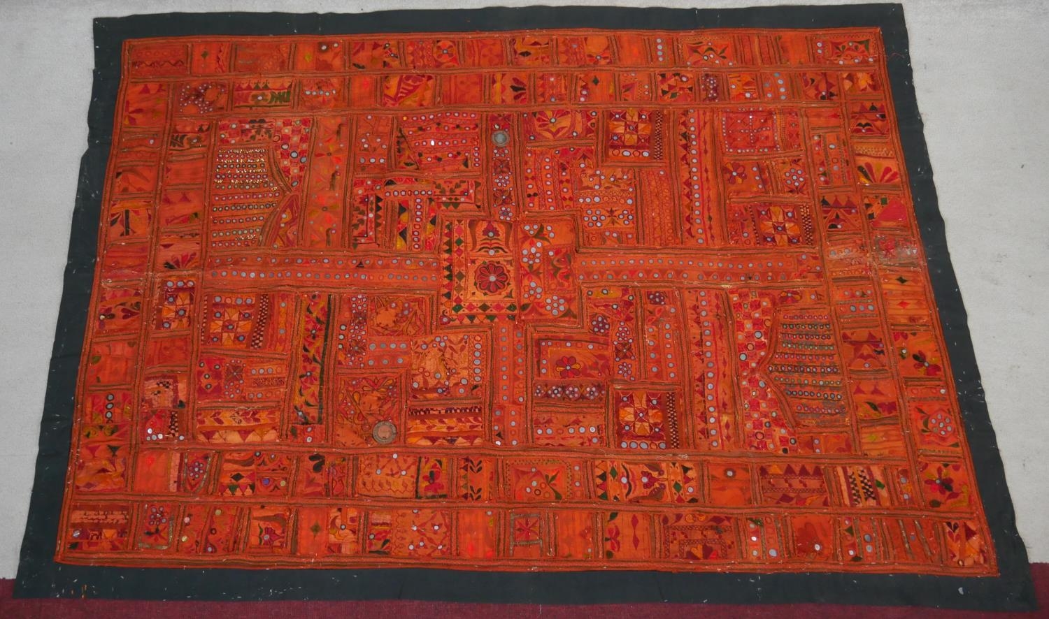 An Eastern bed covering or wall hanging with patchwork style design inset with mirrored discs. L.218