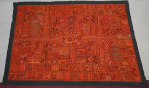 An Eastern bed covering or wall hanging with patchwork style design inset with mirrored discs. L.218