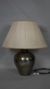 A vintage hammered metal table lamp of bulbous form with silk pleated shade. H.73cm (Including