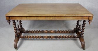 A mid 19th century rosewood library table with turned finials on barleytwist stretchered supports.