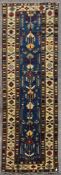 A Kazak style runner with repeating serrated palmette motifs on a sapphire ground contained by