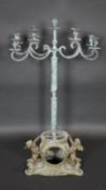 A metal table candelabra with four scrolling branches each with two sconces and a central sconce