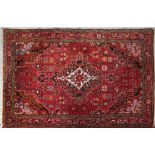 A Shirvan rug with central pole medallion on burgundy field contained by stylised floral spandrels