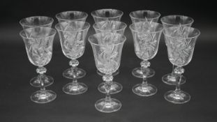 A set of eleven engraved and cut crystal wine glasses with star design and faceted stems. H.17.5cm