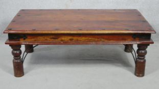 An Indian hardwood and metal bound low table on circular section turned supports. H.41 L.110.5 W.