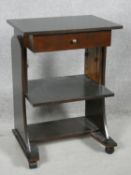 A mid century mahogany side table with patent rise and fall action under tier with frieze drawer