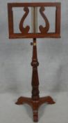 A Regency style mahogany double sided music stand on adjustable reeded pedestal and platform