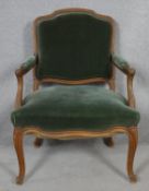 A French style carved walnut framed open armchair in velour upholstery on cabriole supports. H.93