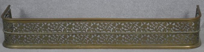 A 19th century pierced floral decorated fire fender. H.18.5 W.125 D.30cm