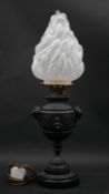 A 19th century embossed metal oil lamp converted to electricity with a later opaque flaming torch