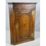A Georgian oak corner cupboard with bird and urn satinwood inlay to the panel door. H.100 W.75 D.