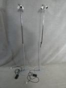 A pair of grey metal and chrome adjustable height floor standing lamps each with three light