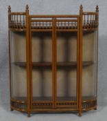 A late 19th century oak glazed miniature display cabinet with convex glass panels resting on ball