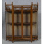 A late 19th century oak glazed miniature display cabinet with convex glass panels resting on ball
