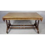 A mid 19th century rosewood library table with turned finials on barleytwist stretchered supports.