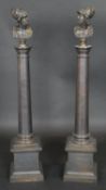 A pair of bronze columns each with a bust of king Menelaus raised on square stepped plinth bases.