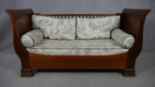 An Empire style mahogany day bed with Toile de Jouy upholstered fitted cushions. Converts to child's