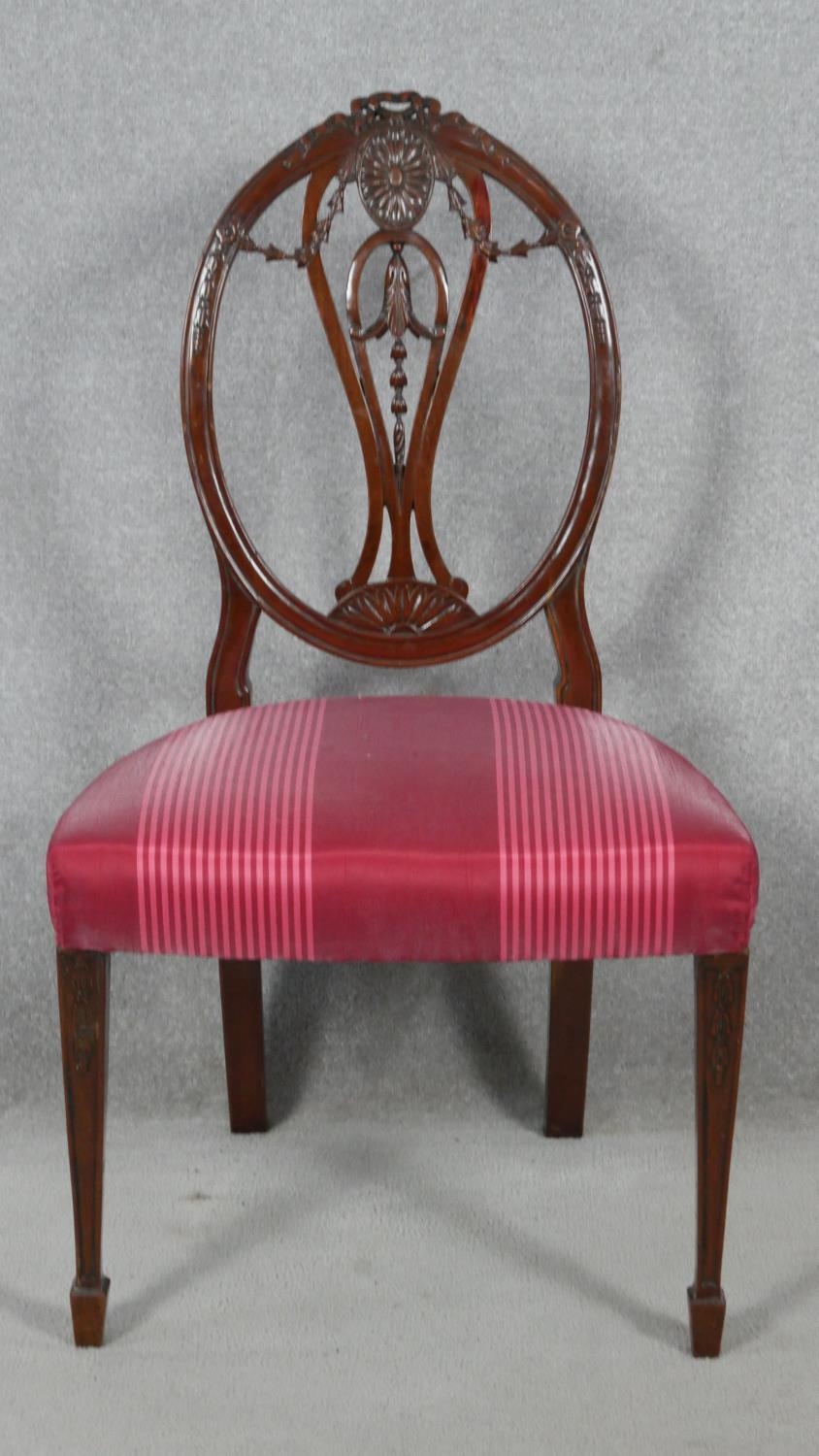 A 19th century mahogany dining chair with carved swag and ribbon detail to the back raised on square