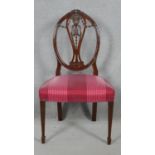 A 19th century mahogany dining chair with carved swag and ribbon detail to the back raised on square