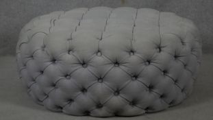 A deep buttoned upholstered footstool. H.36 Dia.93cm