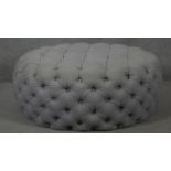 A deep buttoned upholstered footstool. H.36 Dia.93cm