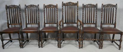 A set of six Carolean style oak dining chairs with carved back rails above drop in seats on