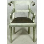 A Regency style embossed metal armchair with ram's head rail back above drop in seat on sabre