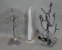 A glass table lamp in the shape of a candle flame and two other metal table lamps. H.65cm (Tallest)