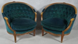 A pair of French style carved beech framed tub armchairs in deep buttoned velour upholstery on