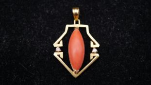 An Art Deco 18 carat yellow gold and coral pendant, set with two round brilliant cut diamonds and