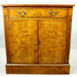 A Georgian style burr elm and satinwood strung side cabinet with frieze drawer above panel doors