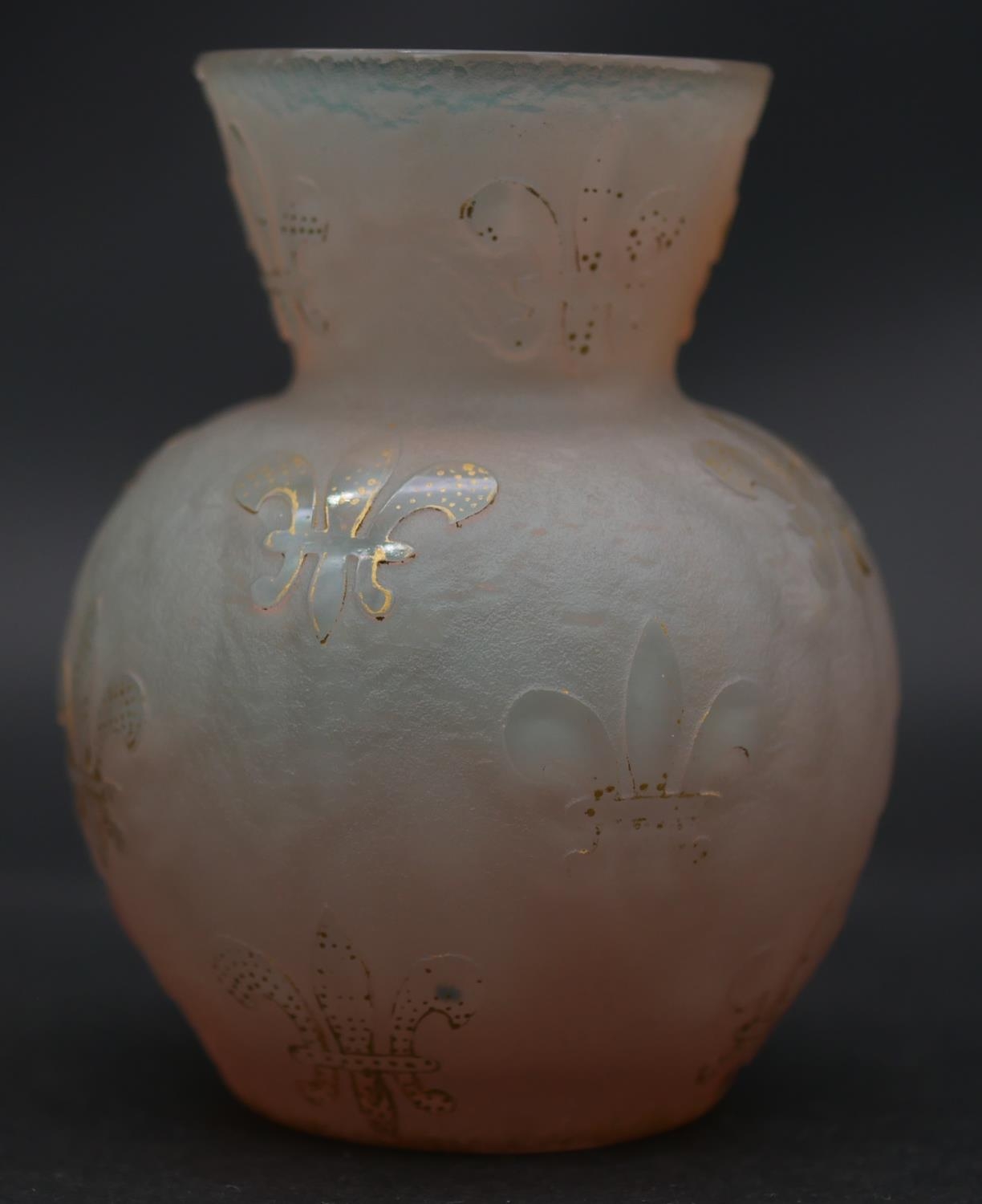 A Daum ovoid glass vase with flared neck and all over gilded Fleur de Lys decoration on a textured