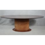 A contemporary oval dining table on maple pedestal base. H.76 L.220 W.120cm